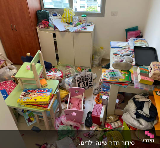 חדר מבולגן עם צעצועים, בגדים, שולחנות וכיסאות קטנים